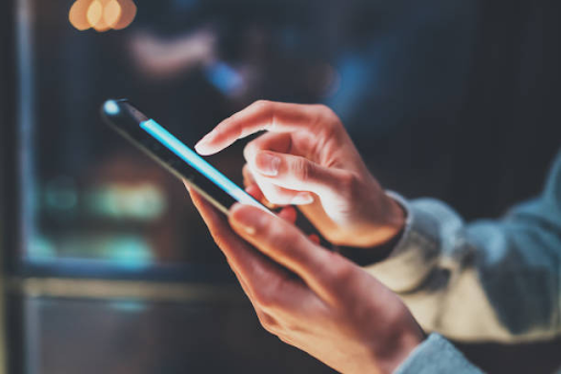 A person interacting with a smartphone, highlighting the importance of mobile app backend development.